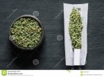 grinder-crushed-cannabis-flowers-not-twirled-joint-weed-background-black-wooden-table-top-view...jpg